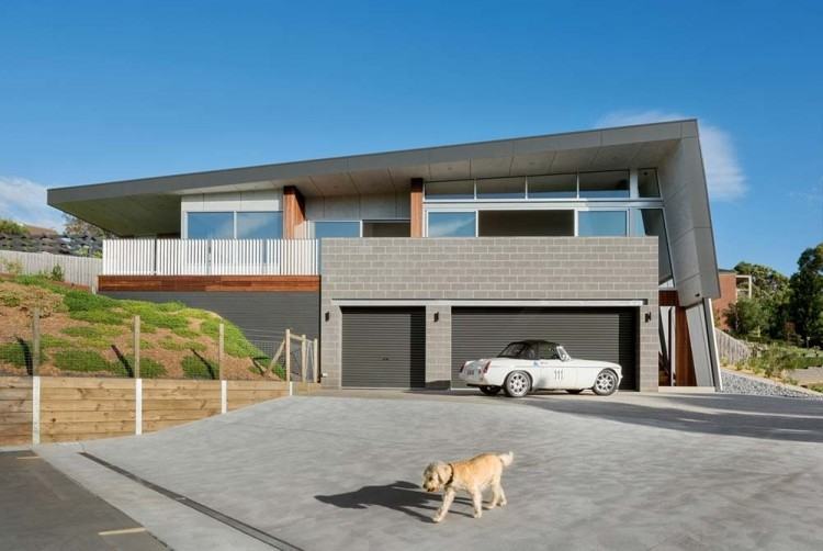 This sloped roof on this modern house helps collect rain water and shields  the interior of the home from the harsh Australian heat