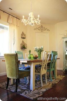 Lamp above wooden table with flowers in modern grey dining room interior with  chairs